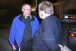 Law enforcement chaplains respond to police calls at all times of the day and night. Father Steve Schwab, the Catholic chaplain for the Marion County Sheriff’s Department, discusses a suicide case with William Arnold, a Marion County deputy coroner.