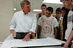 Roncalli High School teacher James Ratliff shows a blueprint to students during one of his architecture classes. Ratliff’s students have won a national architectural design contest 10 times in the past 18 years. (Photo by John Shaughnessy)