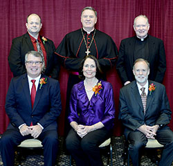 An archdiocesan celebration of Catholic education on Oct. 26, 2015, honored four individuals whose Catholic values mark their lives. Sitting, from left, are honorees Tom Dale, Dr. Marianne Price and Dr. Frank Price. Standing, from left, are honoree Dave Gehrich, Archbishop Joseph W. Tobin and keynote speaker, Holy Cross Father Timothy Scully. (Photo by Rob Banayote)