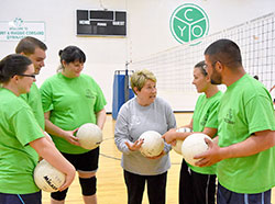 For more than 40 years, Bernie Price has worked for the archdiocese’s Catholic Youth Organization and has led the high school youth group at Good Shepherd Parish in Indianapolis. Here, she is pictured in the center of five former members of the youth group who now play volleyball together in the archdiocese’s Young Adult Ministry sports program. Katie Mracna, left, Zach Burns, Stacia Smith, Amanda Hubenthal and Greg Kocher reunite with Price. (Submitted photo)