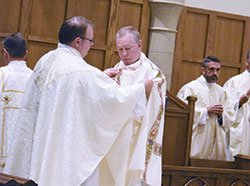 Father C. Ryan McCarthy, left, places a deacon’s dalmatic on transitional Deacon Luke Reese during a May 31 ordination Mass at the Cathedral of Our Lady of Walsingham in Houston in which Deacon Reese and two other men were ordained for the Personal Ordinariate of the Chair of St. Peter. Father McCarthy is pastor of Our Lady of the Most Holy Rosary Parish in Indianapolis, where members of the ordinariate in central and southern Indiana worship. (Submitted photo)