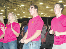 Three members of the Archdiocesan Youth Council show their enthusiasm in reacting to the antics and energy of the musical group Popple during the 2016 Indiana Catholic Youth Conference at the Indiana State Fairgrounds on Nov. 6. Jenna Geise of St. Joseph Parish in Shelbyville, left, Ethan Huntzinger of SS. Francis and Clare of Assisi Parish in Greenwood, and Matt Voglewede of St. Malachy Parish in Brownsburg join in the fun. (Photo by John Shaughnessy)