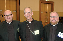Msgr. William F. Stumpf, archdiocesan administrator, left, Archbishop Paul D. Etienne of Anchorage, Alaska, and Father Joseph Newton, left, archdiocesan vicar judicial, pose for a photo before the start of the spring meeting of the U.S. Conference of Catholic Bishops in Indianapolis on June 14. (Photo by John Shaughnessy)