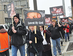 Participants pray the rosary as they walk along North Meridian Street in Indianapolis during the Jan. 22, 2017, solemn observance of the legalization of abortion that occurred on Jan. 22, 1973. This year’s inaugural Indiana March for Life, hosted by the archdiocese, the Diocese of Lafayette and Right to Life of Indianapolis, will be open to all and will process around the Statehouse in Indianapolis. (File photo by Natalie Hoefer)