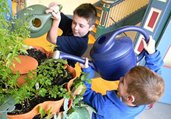 Landyn Hancock, left, and Owen Bader, third graders from Donna Woehler's class at St. Benedict School in Evansville, tend to the garden towers located in the hallway outside of their classroom. The Message photo by Trisha Hannon Smith.