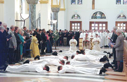 Thirteen deacons from eight dioceses lie prostrate on the floor of Saint Meinrad Archabbey Church in St. Meinrad during the ordination rite on Oct. 28, which was celebrated by Archbishop Daniel M. Buechlein. (Photo courtesy Saint Meinrad School of Theology) 