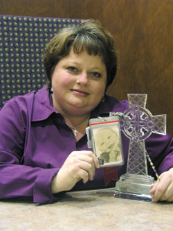 Ann Spitzig-Cady holds a photograph of her 1-year-old grandson, Serj, near a crystal cross—two Christmas gifts that have helped her through a difficult time.