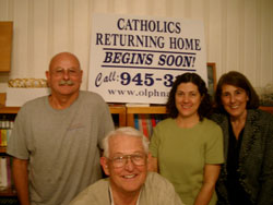 Members of the Catholics Returning Home team in the New Albany Deanery are shown in front of one of the many signs they display in the area to attract participants. They are, from left, Tony Aemmer, Harold Beebe, Karen Jordan and Ann Marie Camarata. (Submitted photo) 