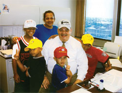 When Janice Knox adopted her niece’s four sons in 2004, the boys asked to have their picture taken with the commissioner who approved the adoption. From left, Elijah, Tuskany, Janice, Israel and Jonathan share their celebration with Mark Battise, a commissioner for the Marion County Superior Court 8 Probate Division. (Submitted photo) 