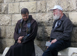 Franciscan Father Peter Vasko, president of the Franciscan Foundation for the Holy Land, sits with St. Monica parishioner Dan Crowe of Indianapolis outside the Tomb of Lazarus in the Holy Land during a pilgrimage last November. (Submitted photo) 