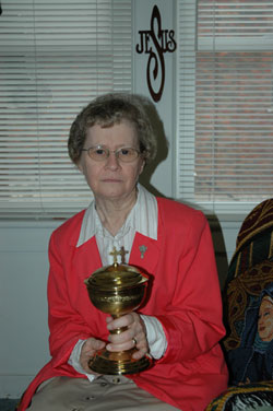 Franciscan Sister Shirley Gerth, parish life coordinator, holds a ciborium taken out of the burned church. (Photo by Mary Ann Wyand) 