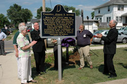 Helping unveil this state historical marker on July 22 in front of the birthplace of Cardinal Joseph Elmer Ritter at 1218 E. Oak St. in New Albany are, from left, Holy Family parishioners Virginia and Paul Lipps of New Albany; Msgr. Joseph F. Schaedel, vicar general; David Hock, a member of Our Lady of Perpetual Help Parish in New Albany and chairman of the Cardinal Ritter Birthplace Foundation; and Bishop Robert J. Hermann, auxiliary bishop of St. Louis. Virginia Lipps is the niece of the late cardinal, who was the archbishop of Indianapolis and later of St. Louis.