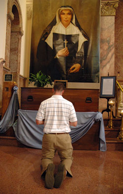 Seminarian Dustin Boehm, a member of Our Lady of the Greenwood Parish in Greenwood, kneels in prayer before the remains of St. Theodora Guérin during a seminarian pilgrimage on Aug. 15 in the Church of the Immaculate Conception at Saint Mary-of-the-Woods, the motherhouse of the Sisters of Providence.