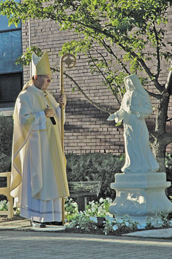 Archbishop Daniel M. Buechlein stands in prayer on Sept. 12 after blessing a statue of St. Theodora Guérin in the courtyard at St. Joseph University Church in Terre Haute.	