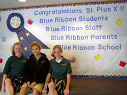 St. Pius X seventh-grade students, from left, Gabby LaFrance, Gabrielle Nondorf and Emily Lux, pose in front of a poster proclaiming the Indianapolis school’s selection as a 2007 Blue Ribbon School of Excellence by the U. S. Department of Education. (Submitted photo) 
