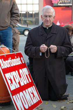 Archbishop Joseph E. Kurtz of Louisville kneels in prayer in front of an abortion clinic in downtown Louisville on Nov. 10 with 300 pro-life supporters from southern Indiana and Kentucky.
