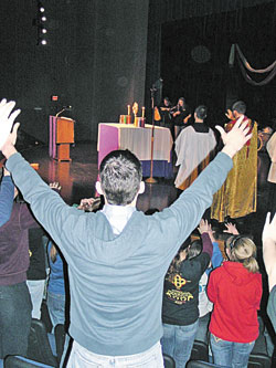 A participant at the March 3-4 Archdiocesan High School Youth Rally held at Our Lady of Providence Jr./Sr. High School in Clarksville raises his hands in prayer while joining others in eucharistic adoration. (File photo/Katie Berger) 