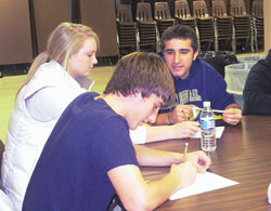 St. Christopher Parish confirmation students, left, Mary Ording, 17, a junior at Cathedral High School; Blake Elliott, 17, a junior at Zionsville High School; and Tyler Sexton, 17, a junior at Cathedral High School, discuss questions during a meeting. The topic for this meeting focused on issues of everyday life and its relation to the sacrament.	