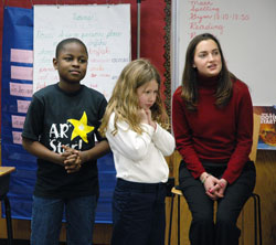 Central Catholic School third-graders Cedric Georges, left, from Cape Haitian, Haiti, and Avery Cook, center, participate in a lunchtime guessing game on Jan. 10 with their teacher, Rachel Brubaker, right, and classmates. Cedric and his older sister, Sabrina, moved to Indianapolis from Haiti with their mother, Rose Georges, last August. Haitians speak French, and the children did not know any English when they immigrated to the U.S. five months ago. The family attends the traditional Latin Mass at Our Lady of the Most Holy Rosary Parish in Indianapolis. (Photo by Mary Ann Wyand) 