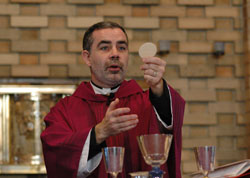 Father Joseph Moriarty elevates the Eucharist during a Feb. 11 Mass at the Our Lady of Fatima Retreat House chapel in Indianapolis on the feast of Our Lady of Lourdes and in observance of the World Day of the Sick. The Mass was also celebrated for the intention of Archbishop Daniel M. Buechlein, who is undergoing chemotherapy treatments for Hodgkin’s lymphoma. The day of reflection included instructions on the Spiritual Exercises of St. Ignatius of Loyola. (Photo by Mary Ann Wyand)	
