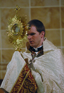 Father Jonathan Meyer carries the Blessed Sacrament in the monstrance in a procession during Benediction on Feb. 20 at Our Lady of the Most Holy Rosary Church in Indianapolis as part of a Lenten “40 Hours Devotion.” He is the associate pastor of St. Luke the Evangelist Parish in Indianapolis and director of youth ministry for the archdiocese. (Photo by Mary Ann Wyand) 
