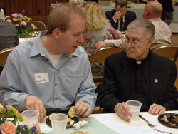 Seminarian Tim Wyciskalla, left, a sophomore at Bishop Simon Bruté College Seminary in Indianapolis, and retired Father Patrick Commons, talk on May 7 during a reception for members of the Miter Society at the Archbishop O’Meara Catholic Center. The generosity of Miter Society members and other Catholics across the archdiocese supports priestly formation for seminarians and the needs of retired priests. (Photo by Sean Gallagher)