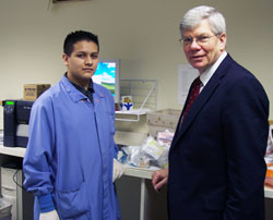 As part of his work-study program at Providence Cristo Rey High School, Angel Cruz, left, works one day a week at AIT Laboratories in Indianapolis. He is pictured with Michael Evans, the founder and owner of the company, who became involved in the high school because of a teacher who influenced his life years ago. (Submitted photo)	
