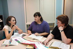 Using a Bible timeline chart, Alexa Puscas, left, director of religious education at St. Pius X Parish in Indianapolis, discusses the meaning of a Scripture passage on Sept. 3 with parishioners Calli Eickhoff, center, and Kathy Loeffler. Eickhoff is a financial assistant at the Indianapolis North Deanery parish and Loeffler is the parish secretary. They participated in The Great Adventure Bible Study Timeline last spring. (Photo by Mary Ann Wyand) 