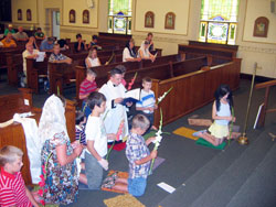 Father Shaun Whittington, pastor of St. John the Baptist Parish in Osgood, prays on July 16 in adoration of the Blessed Sacrament with children during a children’s holy hour. The prayer service is part of the Apostolate for Family Consecration’s “Consecration in Truth” catechetical program. (Photo by Jennifer Lindberg) 