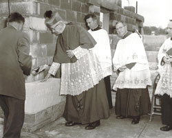 In this Archive photo, Archbishop Paul C. Schulte touches the cornerstone of St. Matthew the Apostle Church after he blessed it during the construction of the parish’s facilities in 1958. Priests assisting Archbishop Schulte were, from left, Father Albert Diezeman, St. Matthew’s first pastor; Msgr. Henry Hermann and Father Cyril Conen. (Submitted photo) 