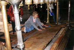 Mary Jo Thomas Day, director of religious education at St. Monica Parish in Indianapolis, kneels down in the Church of the Holy Sepulchre in Jerusalem and places her hands on the stone of unction where Jesus was prepared for burial. She participated in a pilgrimage to the Holy Land with St. Monica parishioners last April as part of a three-month sabbatical. Thomas Day and her family are members of Holy Cross Parish in Indianapolis. (Submitted photo) 