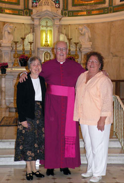 Standing with Msgr. Joseph F. Schaedel, vicar general, in the Blessed Sacrament Chapel at SS. Peter and Paul Cathedral in Indianapolis on May 14 are Paula Slinger, left, and Darlene Cole, right, the most recent graduates of the archdiocese’s Ecclesial Lay Ministry formation program. (Photo by Kamilla Benko) 