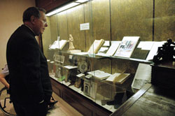 Archbishop Daniel M. Buechlein looks at artifacts that are displayed behind glass at the Old Cathedral Library in Vincennes, Ind., on March 18. In celebration of the 175th anniversary of the Archdiocese of Indianapolis, Archbishop Buechlein will lead a second pilgrimage for adults to historic Vincennes on Sept. 12. (File photo by Mary Ann Wyand) 