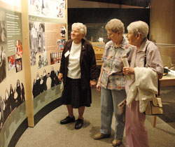 Oldenburg Franciscan Sisters Rita Vukovic, from left, Ruth Breig and Jean Wolf read the display about their order on Aug. 27 at the Cincinnati Museum Center. (Photo by Mary Ann Wyand)