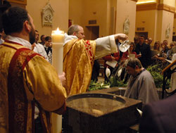 Benedictine Father Julian Peters, at the time the administrator pro-tem of SS. Peter and Paul Cathedral Parish in Indianapolis, baptizes Scott Warpool during Cathedral Parish’s Easter Vigil on March 22, 2008. The Easter Vigil is the culmination of the journey of faith taken by people seeking to enter into the full communion of the Church through the Rite of Christian Initiation of Adults (RCIA). Proposed archdiocesan RCIA guidelines are currently being tested in several parishes across central and southern Indiana. (File photo by Sean Gallagher) 