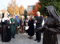Providence Sister Susan Paweski, left, portrays St. Theodora Guérin during the closing of the inaugural St. Mother Theodore Guérin Fest at Saint Mary-of-the-Woods on Oct. 25. She is flanked to the right by Providence Sister Barbara Doherty, chairperson of the planning committee. At right is Providence Sister Denise Wilkinson, general superior, and Pierre Vimont, French ambassador to the United States. In the foreground is the recently dedicated statue of St. Theodora. The statue, a recent addition to the sister’s campus, was dedicated on June 28. (Submitted photo) 