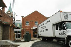 Movers with Two Men and a Truck carry furnishings into the new Holy Family Shelter on Nov. 19, which was the 25th anniversary of the opening of the first Holy Family Shelter at 30 E. Palmer St. on the near south side in Indianapolis. The new shelter is located at 907 N. Holmes Ave. next to Holy Trinity Church on the near west side in Indianapolis. (Photo by Mary Ann Wyand)