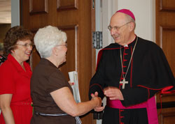 Bishop William L. Higi of Lafayette greets Sharon Butler, a member of Sacred Heart Parish in Fowler, Ind., in the Lafayette Diocese during the May 31, 2009, celebration of the 50th anniversary of his ordination to the priesthood and the 25th anniversary of his ordination to the episcopate. (Photo courtesy of The Catholic Moment)