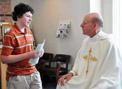 St. Paul the Apostle parishioner Ethan Gill of Greencastle, a longtime altar server and student at Greencastle Middle School, says goodbye to Father Stephen Jarrell during a June 27 farewell reception. Father Jarrell now serves as the pastor of Christ the King Parish in Indianapolis. “He just brought us all together,” Ethan said. “I’m going to miss him.” (Photo by Mary Ann Wyand)