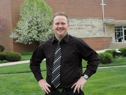 Youth motivational speaker Ryan Moran of Indianapolis, a 2000 graduate of Bishop Chatard High School, stands in front of the North Deanery interparochial high school. He presents motivational and leadership programs to students at junior and senior high schools and youth organizations throughout the country. He is a member of Christ the King Parish in Indianapolis. (Photo by Mary Ann Wyand)