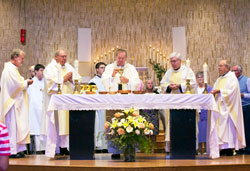 Archbishop Daniel M. Buechlein, center, prays at the altar during a Sept. 19 Mass at St. Michael Church in Greenfield. The Mass celebrated the 150th anniversary of the founding of the parish. Joining Archbishop Buechlein at the altar are, from left, Father Stanley Herber, Deacon Wayne Davis, Benedictine Father Severin Messick, St. Michael’s current pastor, and Father Joseph Riedman. Father Herber and Father Riedman are previous pastors. Standing behind the clergy are altar servers and extraordinary ministers of holy Communion. (Submitted photo)