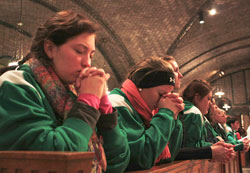 Zoe Kidwell, 17, left, and Angela Fowler, 18, students at Roncalli High School in Indianapolis, pray after receiving Communion during Mass before the annual March for Life on Jan. 24. Pilgrims from the Archdiocese of Indianapolis filled the crypt church of the Basilica of the National Shrine of the Immaculate Conception in Washington, D.C., for the Mass. (Photo by Alea Bowling)