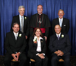Spirit of Service winners, seated from left, are David Jackson, Fiorella Gambetta-Gibson and Charles Guynn. Standing, from left, are award recipient Leo Stenz, Bishop Christopher J. Coyne and former University of Notre Dame head football coach Lou Holtz. (Photo by Rich Clark)