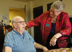 Benedictine Sister Sharon Bierman, longtime administrator of St. Paul Hermitage in Beech Grove, talks with Hermitage resident Harold Dwenger, who is 102. Sister Sharon retired on June 30 after 33 years of ministry at the retirement facility operated by the Sisters of St. Benedict of Our Lady of Grace Monastery. “This is their home,” she said. “The residents feel safe and loved here.” (Photo by Mary Ann Wyand)
