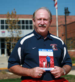 Roncalli High School head football coach Bruce Scifres of Indianapolis holds a copy of his book A Real Man: A Guide to Becoming the Men Our Wives, Children and God Want Us to Be. (Submitted photo/Jay Wetzel)