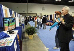 Archbishop Roger L. Schwietz of Anchorage, right, plays Wii baseball with Madelyn Kelty of Louisville, Ky., on Nov. 18 in the National Catholic Youth Conference’s Vocations Village at the Indiana Convention Center in Indianapolis. (Photo by Sean Gallagher)