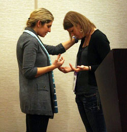 Jackie Francois, left, and Mary Bielski offer up a prayer before beginning a breakout session on Theology of the Body on Nov. 19 at the National Catholic Collegiate Conference in Indianapolis. The passionate and personal presentation had a strong emotional impact on the young adults in attendance. (Photo by Alea Bowling)