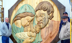 The Weberding brothers stand by the 10-foot high, 400-pound carving of the Holy Family that they created in honor of their late parents, William J. and Monica Weberding. The brothers—Tim, left, William G., right foreground, and Terry, right background—have continued to operate the Weberding Carving Shop in Batesville that their father started 70 years ago. (Submitted photo)