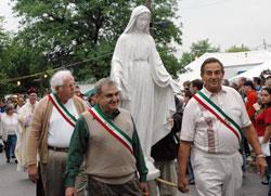 Italian Heritage Society board members, from left, James Divita, Salvatore Petruzzi and John Acceturo of Indianapolis carry a statue of Mary during the religious procession on June 10, 2006, that has been a traditional part of the Italian Street Festival at Our Lady of the Most Holy Rosary Parish in Indianapolis. Heavy rain drenched festival-goers immediately after the Marian procession entered the church with the statue of the Blessed Mother. (File photo by Mary Ann Garber)