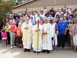 Father Brian Esarey, left, retired Benedictine Archabbot Lambert Reilly and Father Mark Gottemoeller pose on Sept. 16 with members of St. Augustine Parish in Leopold on the grounds of the Tell City Deanery faith community after the celebration of a Mass to mark the 175th anniversary of its founding. Father Esarey is its current pastor. Father Gottemoeller is one of its previous pastors. Archabbot Lambert was the principal celebrant at the anniversary Mass. (Photo by Patricia Happel Cornwell)